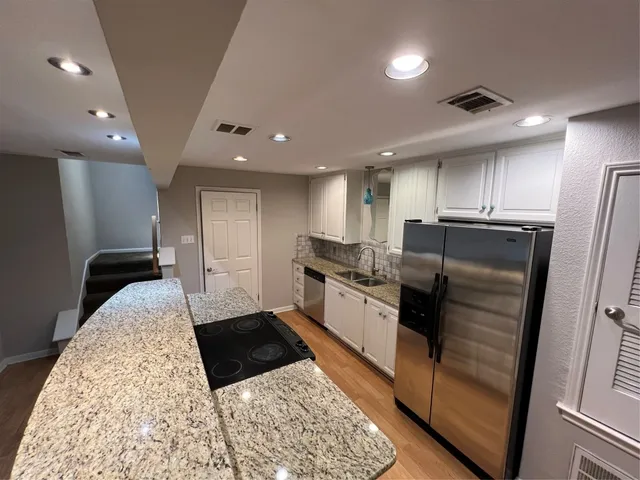 a large kitchen with a sink and stainless steel appliances