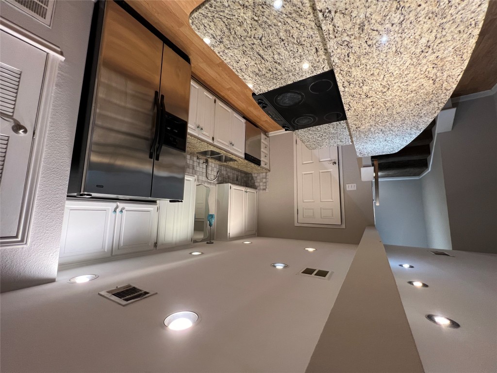 a large kitchen with a sink and stainless steel appliances