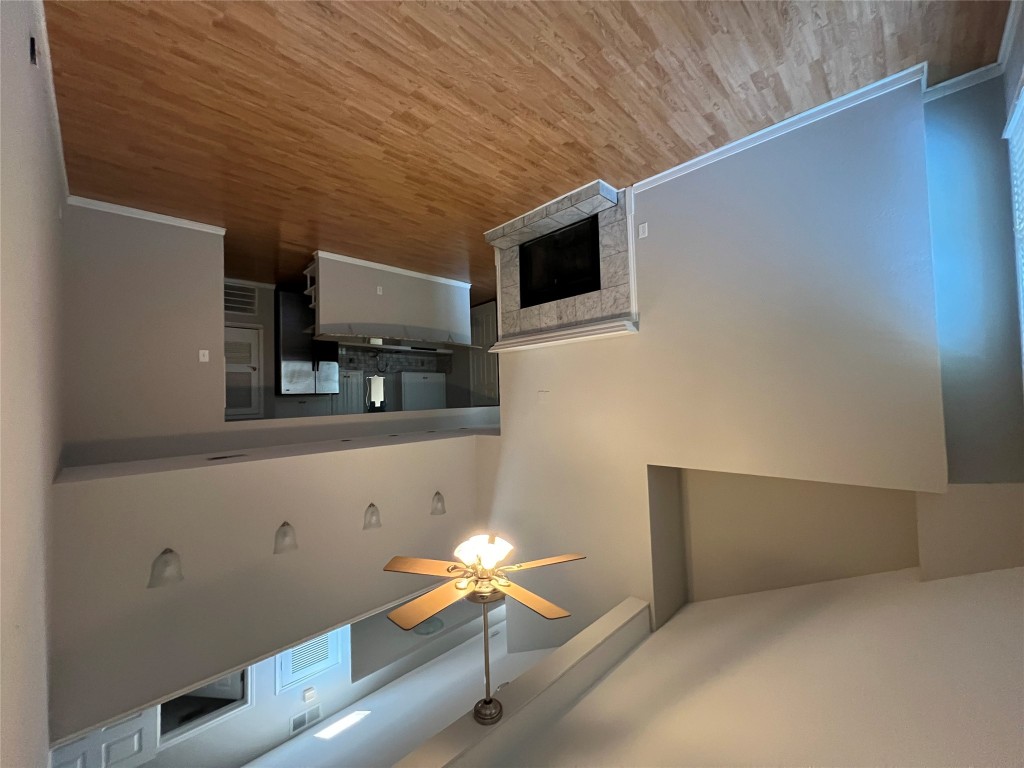 a view of an empty room with a kitchen and a window