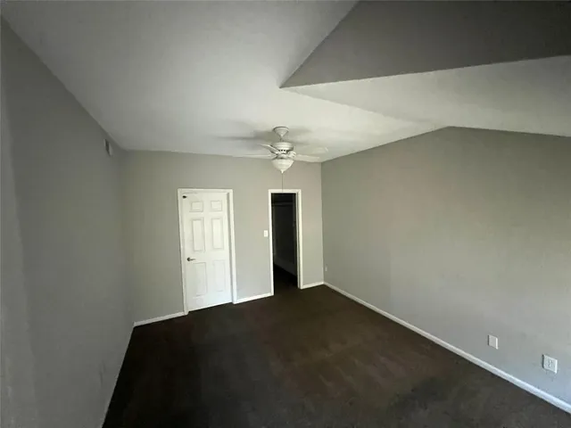 an empty room with windows and cabinet