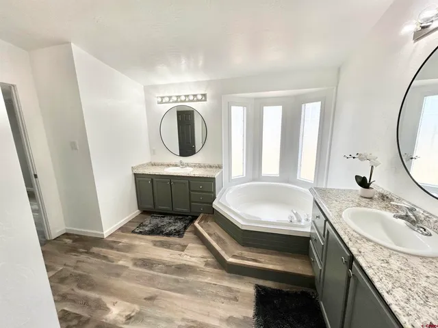 a en suite bathroom with a granite countertop sink and a mirror