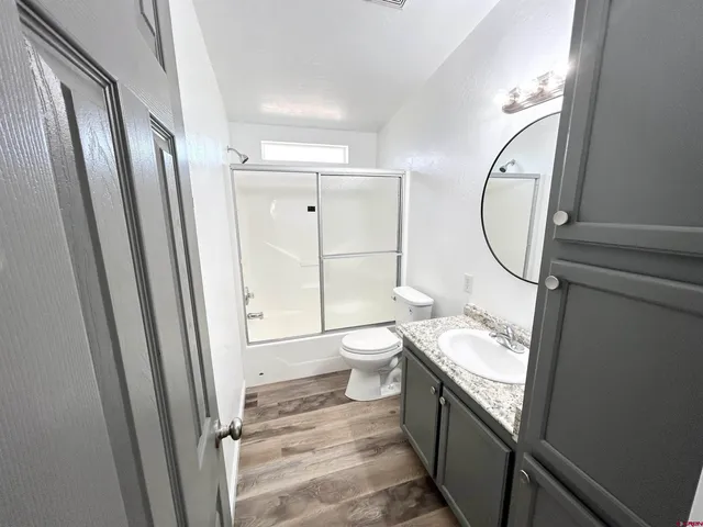 a bathroom with a granite countertop sink toilet and shower view