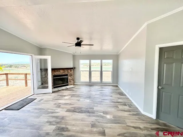 a view of an empty room with a fireplace and a window