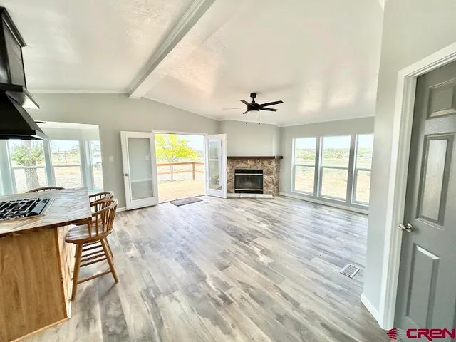a view of empty room with a fireplace and wooden floor