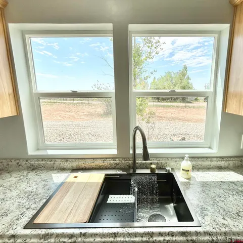 a view of a kitchen that has a sink and a window