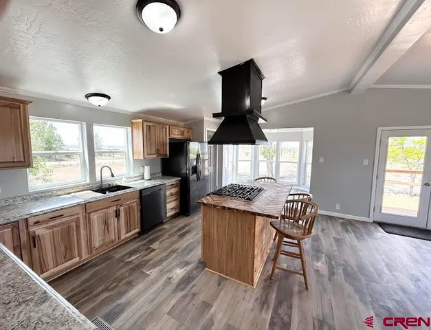 a kitchen with stainless steel appliances granite countertop a sink dishwasher a stove and a refrigerator