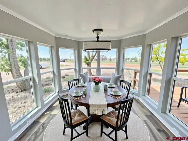 a view of a dining room with furniture large windows and wooden floor
