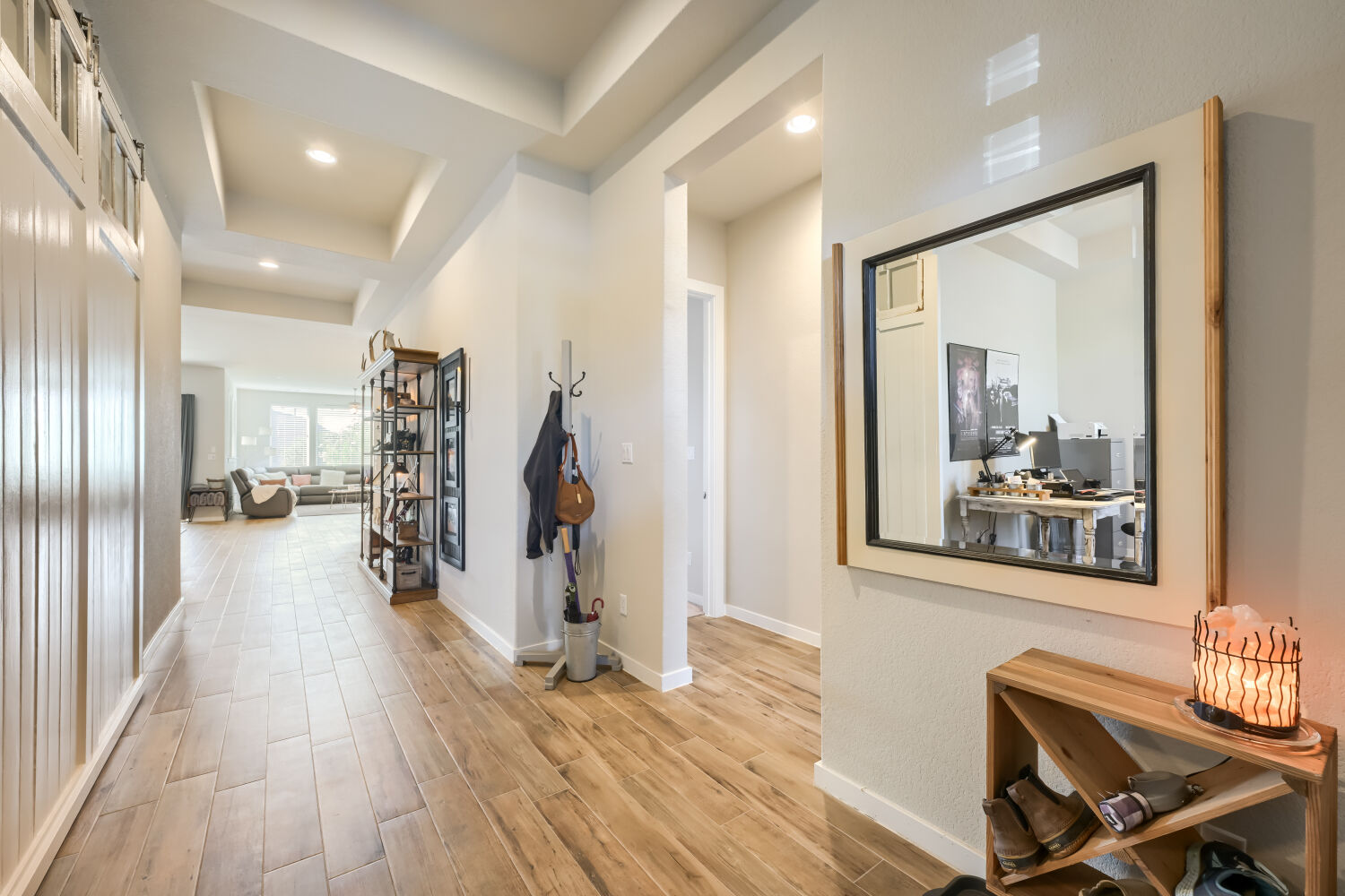 621 Rancho Sienna Loop Georgetown, TX 78628 - Photo 4 of 28 A well-lit hallway with natural wood-look tile flooring leads to a spacious living area.