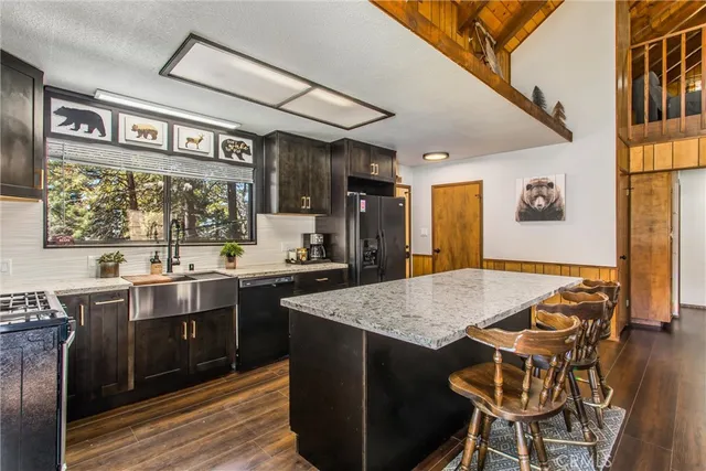 a kitchen with stainless steel appliances granite countertop a stove a sink and a refrigerator