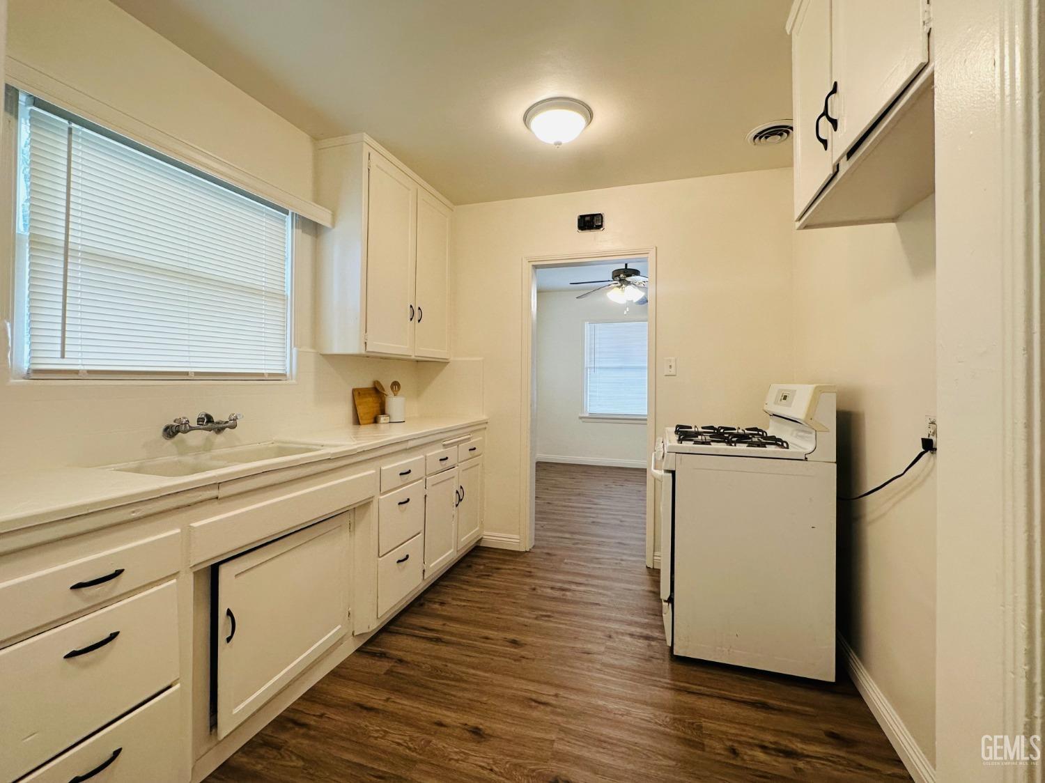 Undisclosed Address Bakersfield, CA 93308 - Photo 12 of 28 a kitchen with sink a refrigerator and white cabinets