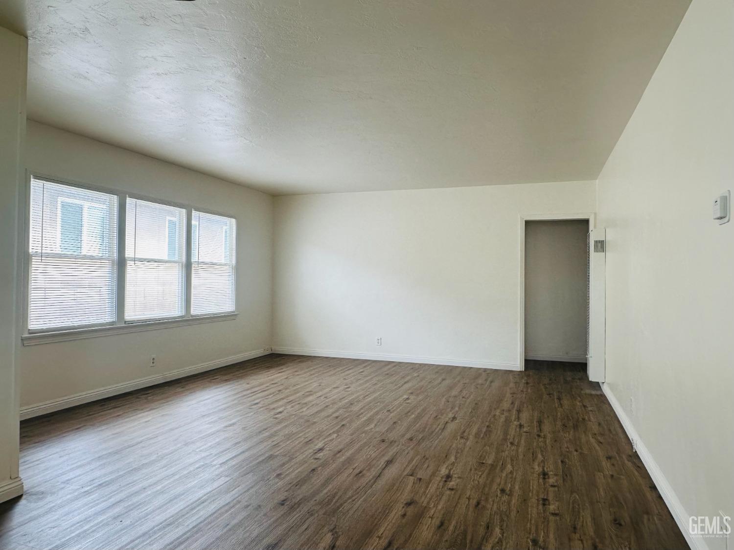 Undisclosed Address Bakersfield, CA 93308 - Photo 13 of 28 an empty room with wooden floor and windows