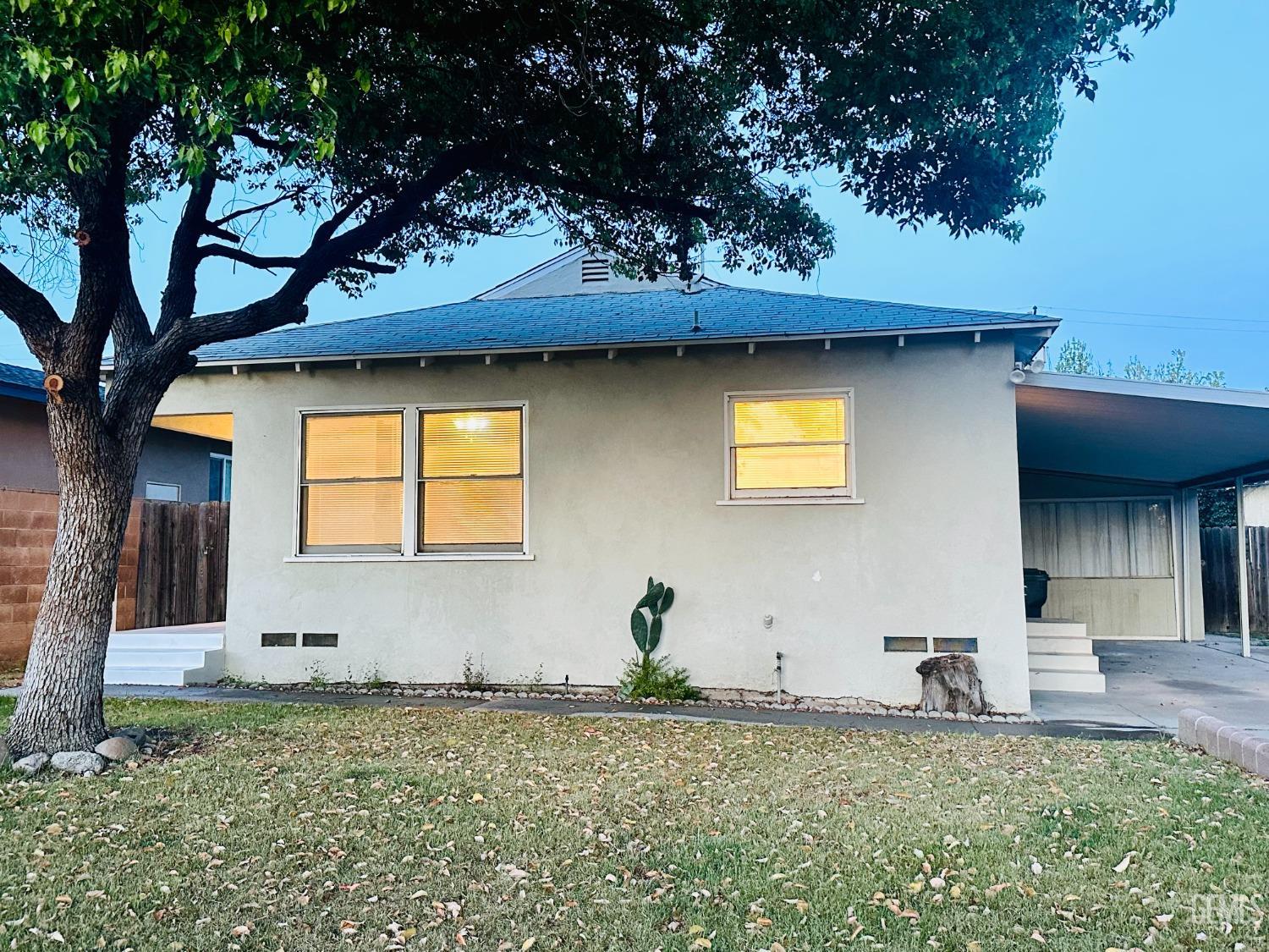 Undisclosed Address Bakersfield, CA 93308 - Photo 2 of 28 a backyard of a house with lots of green space and glass windows