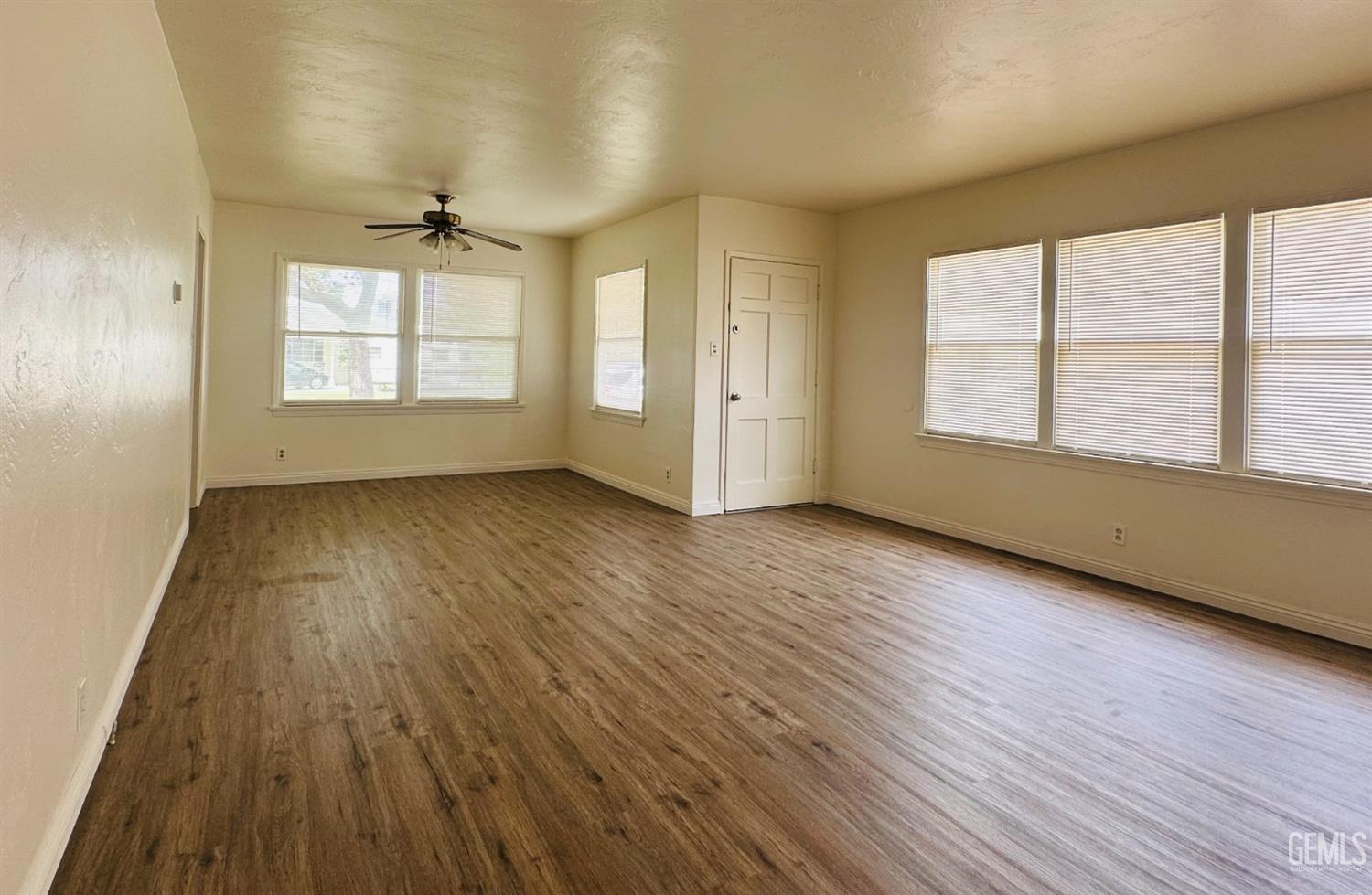 Undisclosed Address Bakersfield, CA 93308 - Photo 6 of 28 an empty room with wooden floor and windows