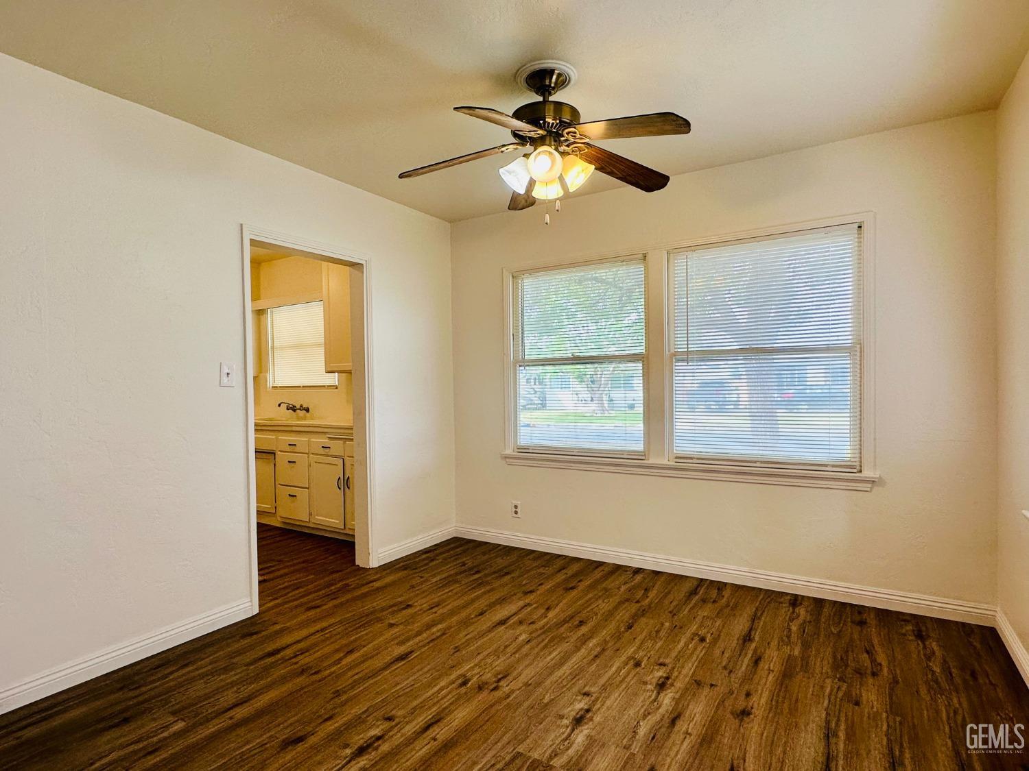 Undisclosed Address Bakersfield, CA 93308 - Photo 7 of 28 a view of an empty room with wooden floor and a window