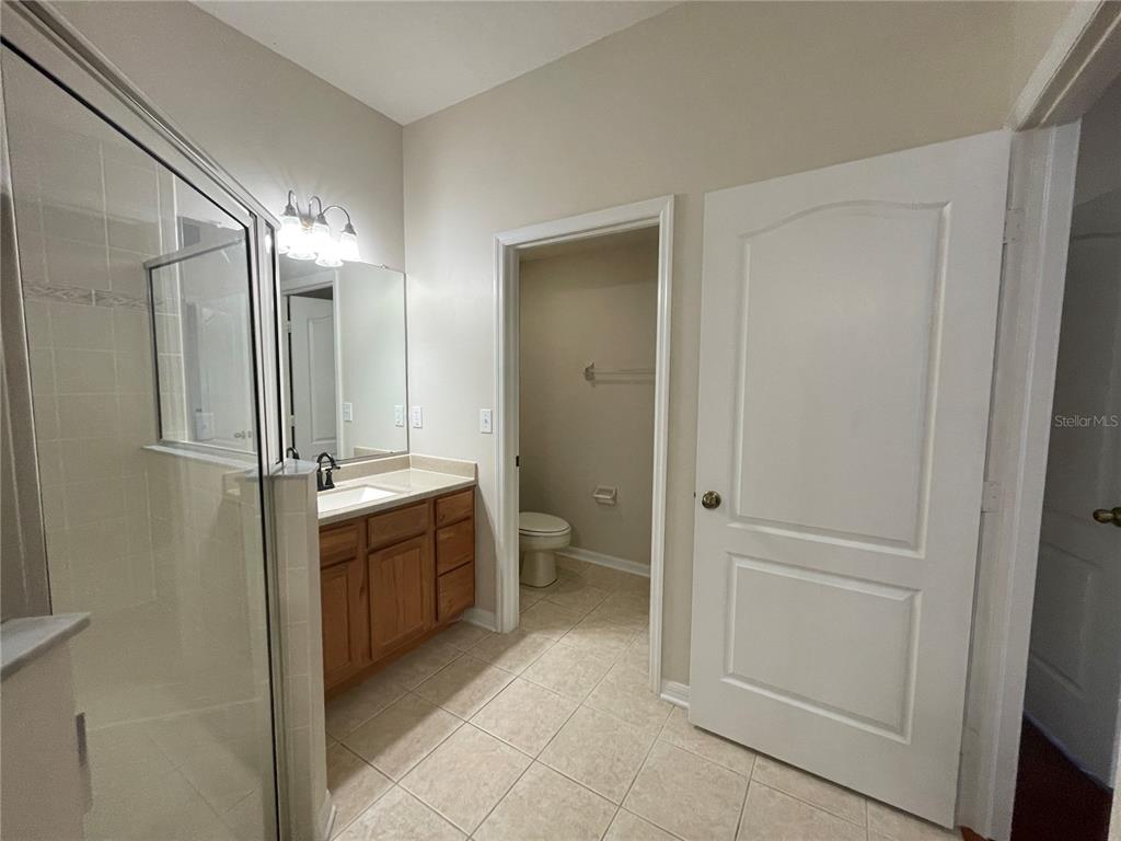 1228 Bensbrooke Drive Wesley Chapel, FL 33543 - Photo 14 of 37 a bathroom with a glass door shower a sink and a toilet