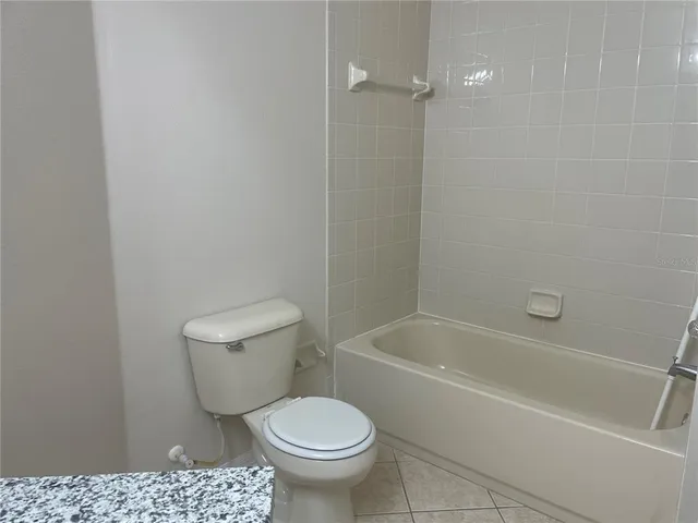 a white toilet sitting next to a bath tub