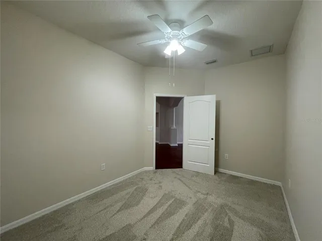 an empty room with an empty space and a chandelier fan