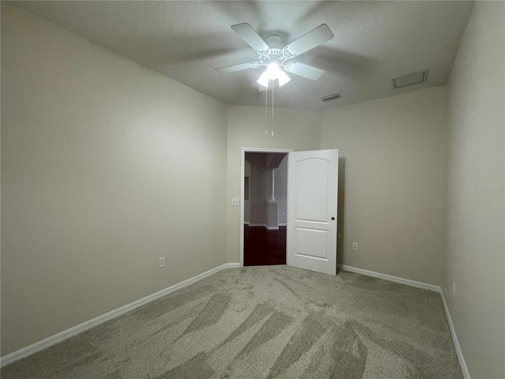 1228 Bensbrooke Drive Wesley Chapel, FL 33543 - Photo 19 of 37 an empty room with an empty space and a chandelier fan