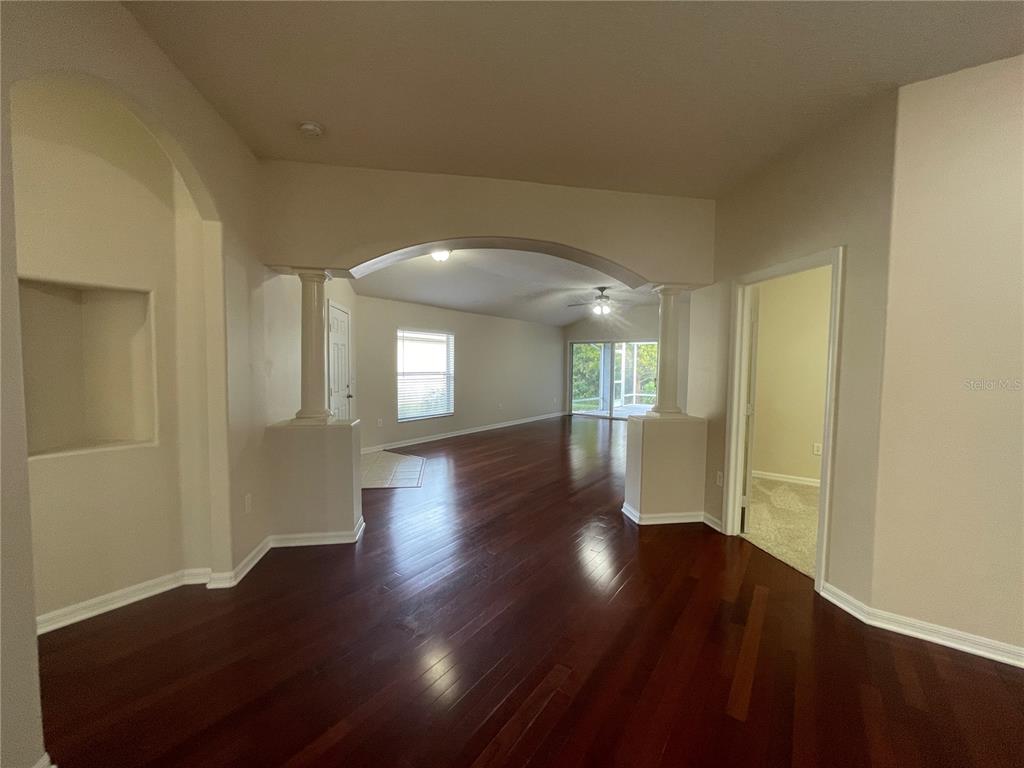 1228 Bensbrooke Drive Wesley Chapel, FL 33543 - Photo 4 of 37 a view of an empty room with wooden floor and a window