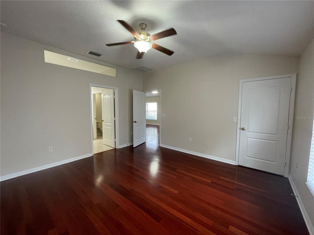 1228 Bensbrooke Drive Wesley Chapel, FL 33543 - Photo 9 of 37 a view of an empty room with wooden floor and a window