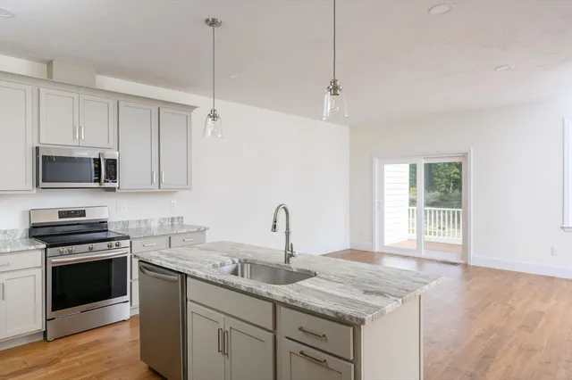 a kitchen with granite countertop a sink and steel appliances