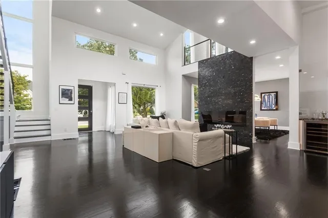 a living room with furniture kitchen view and a wooden floor