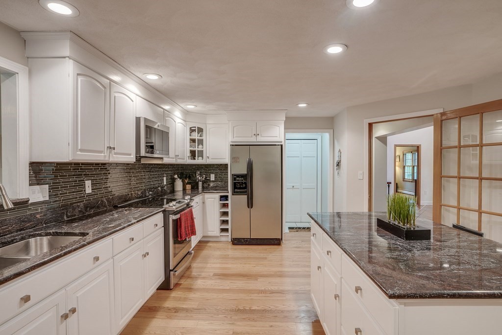 1 Radcliffe Circle Bedford, MA 01730 - Photo 2 of 42 a large kitchen with stainless steel appliances granite countertop a stove refrigerator and cabinets
