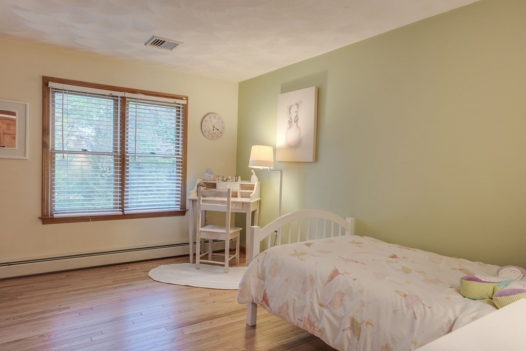 1 Radcliffe Circle Bedford, MA 01730 - Photo 22 of 42 a bedroom with a bed and a table in it next to a window