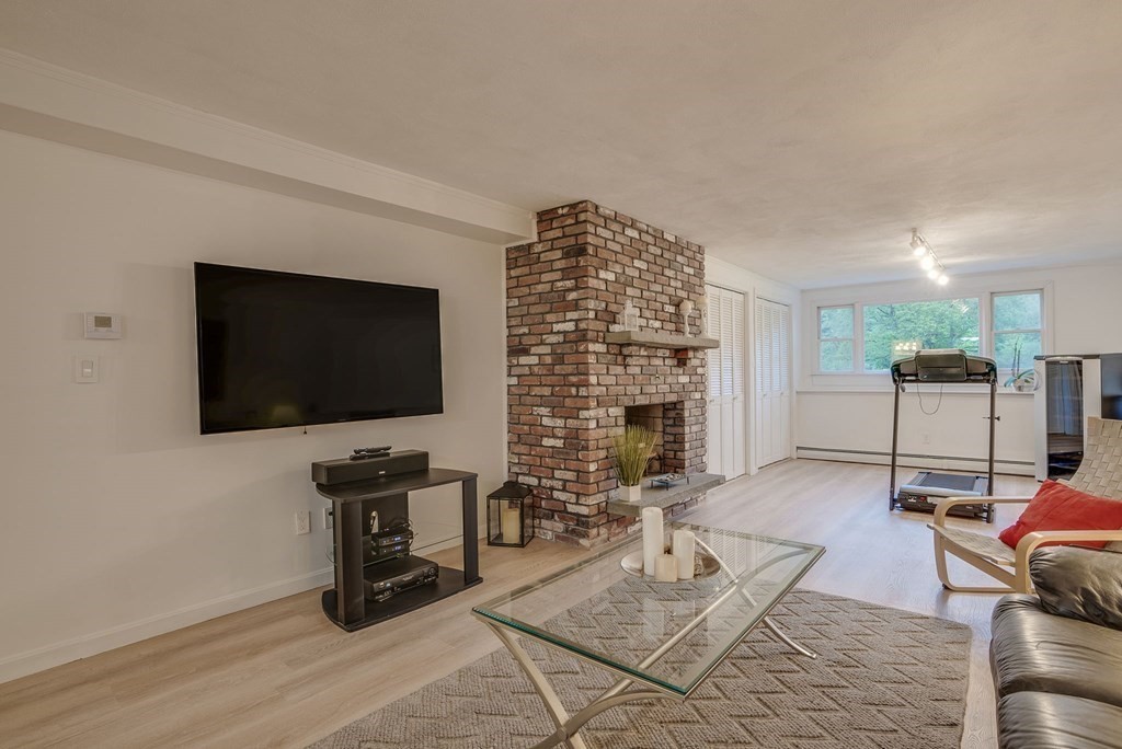 1 Radcliffe Circle Bedford, MA 01730 - Photo 26 of 42 a living room with furniture a flat screen tv and a fireplace