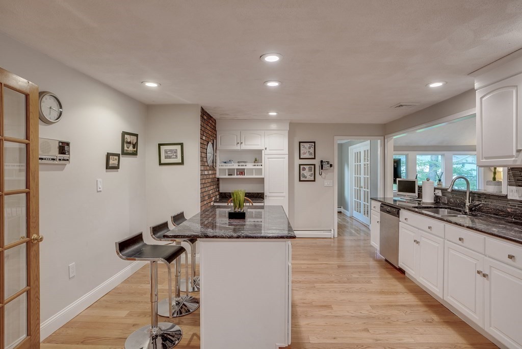 1 Radcliffe Circle Bedford, MA 01730 - Photo 4 of 42 a kitchen with stainless steel appliances kitchen island granite countertop a refrigerator and a sink