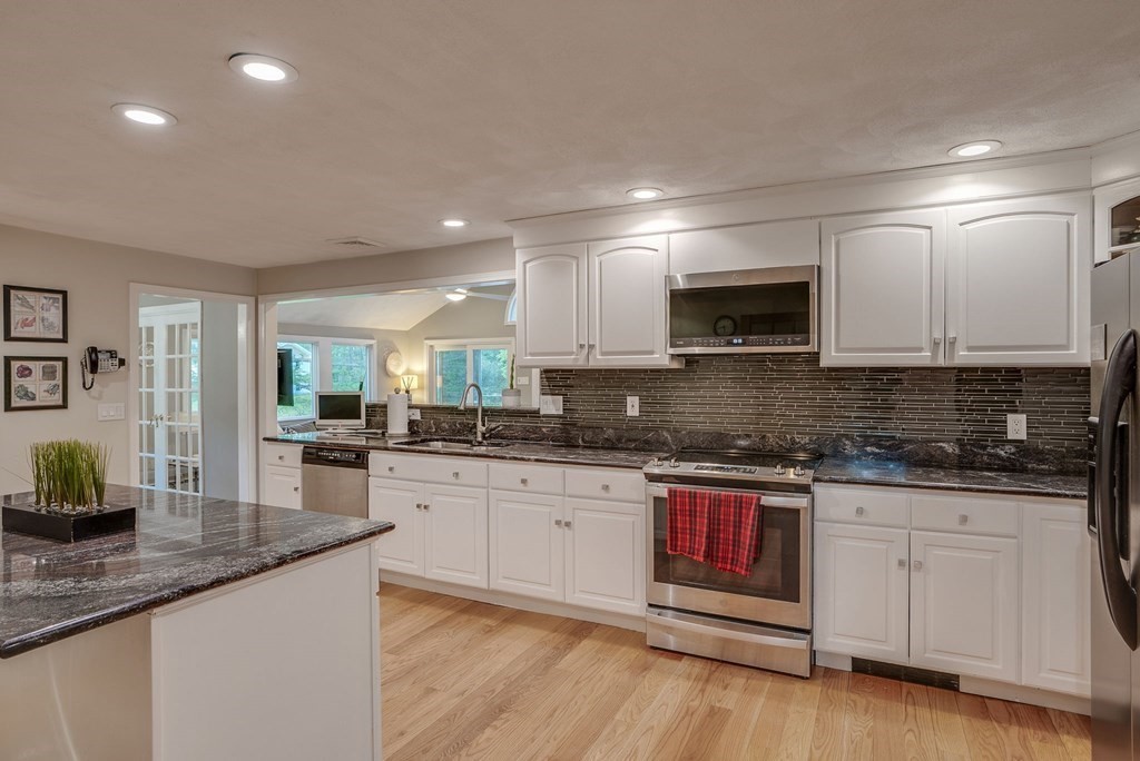 1 Radcliffe Circle Bedford, MA 01730 - Photo 5 of 42 a kitchen with granite countertop a sink and cabinets