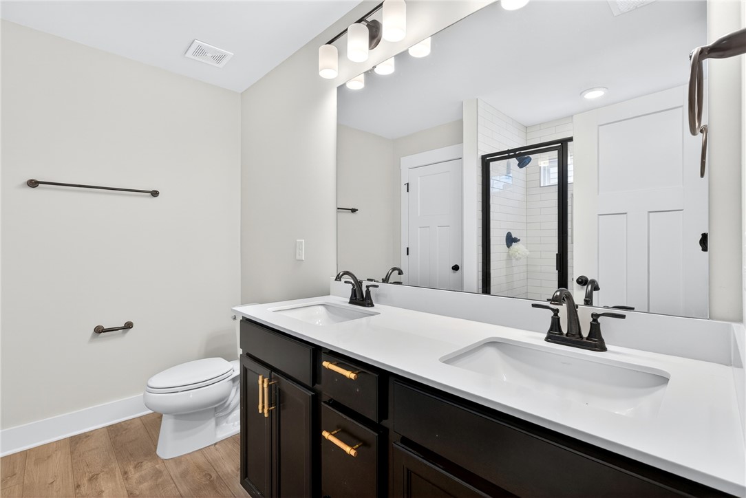 128 Whitman Way Easley, SC 29642 - Photo 18 of 34 This modern bathroom features a double vanity, sleek fixtures, and a spacious shower.