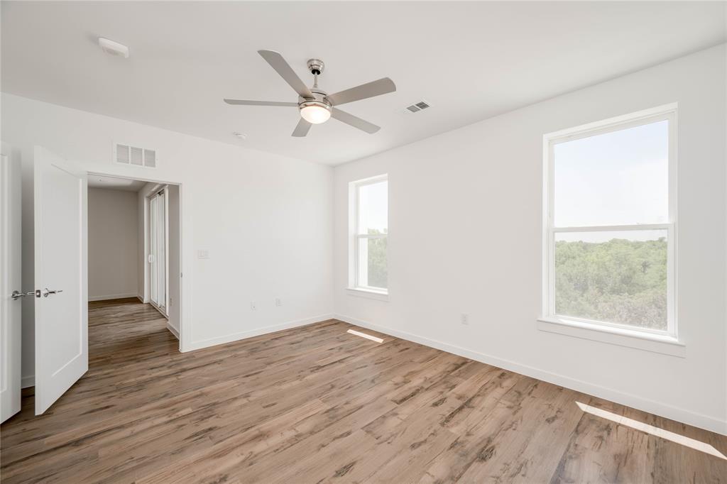 4801 Springdale Road, Unit 1307 Austin, TX 78723 - Photo 9 of 30 an empty room with wooden floor fan and windows