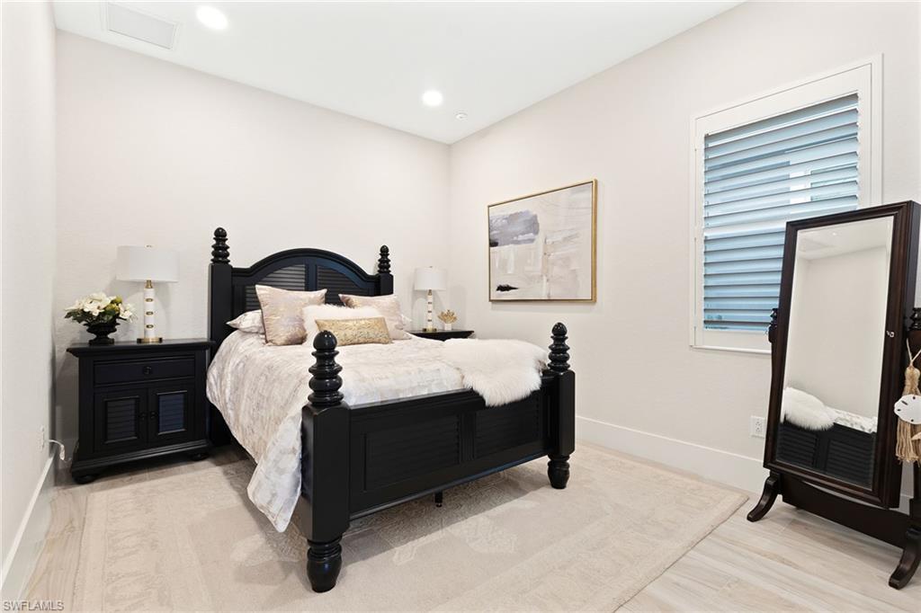 8829 Paradera Court Naples, FL 34112 - Photo 14 of 31 a bedroom with a bed and a mirror