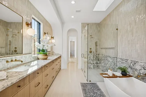 a bathroom with a granite countertop tub sink and mirror