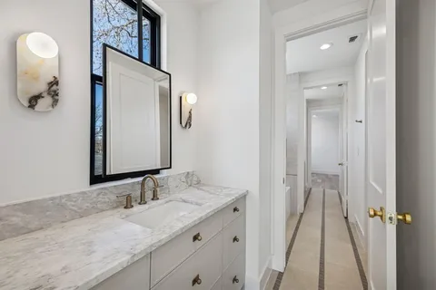 a bathroom with a granite countertop sink vanity and mirror