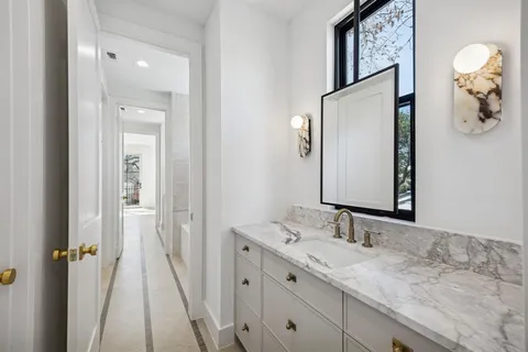 a bathroom with a granite countertop sink vanity and mirror