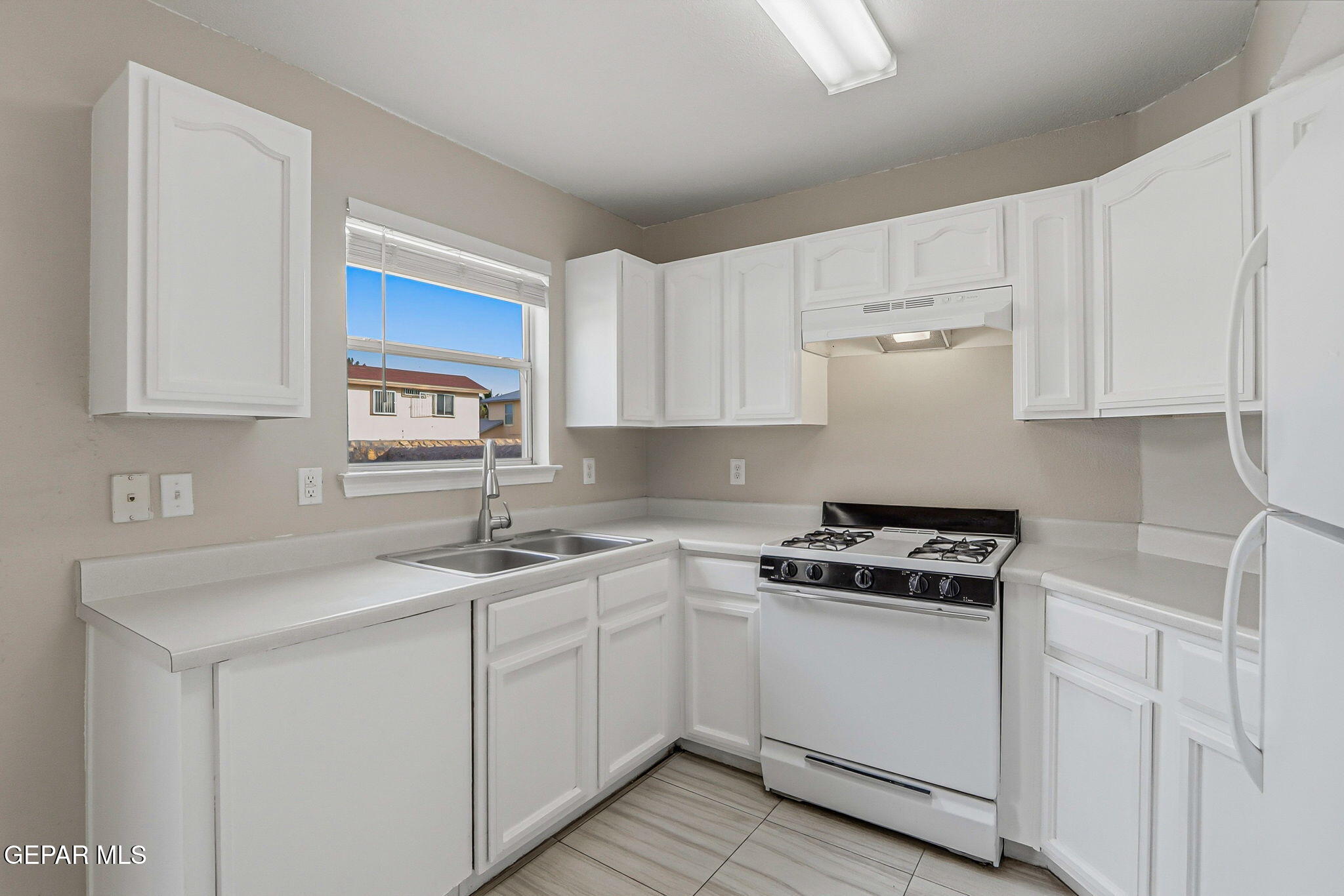 3424 Tierra Cromo Road El Paso, TX 79938 - Photo 9 of 27 a kitchen with cabinets appliances a sink and a window