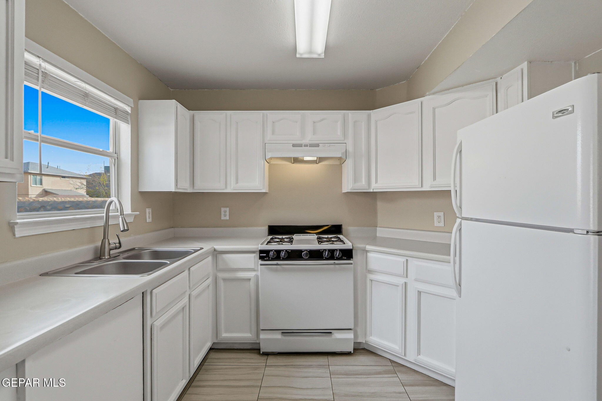 3424 Tierra Cromo Road El Paso, TX 79938 - Photo 10 of 27 a kitchen with a stove white cabinets and white appliances