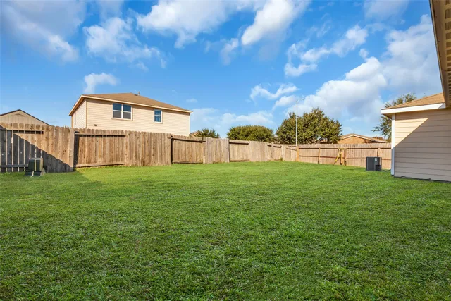 a view of a house with a big yard and large trees
