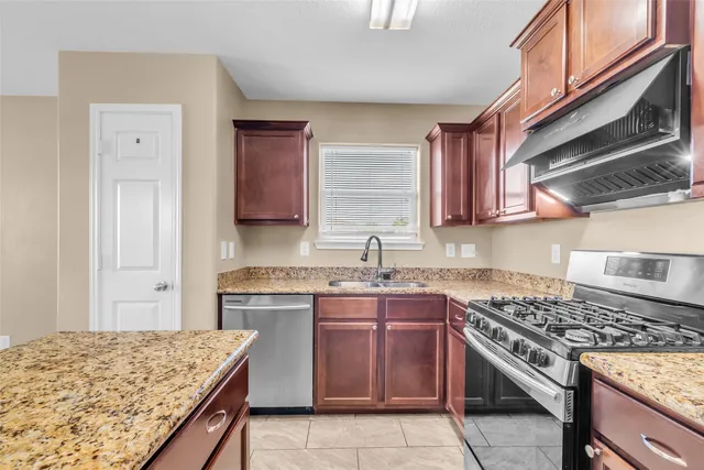 a kitchen with a stove sink and cabinets