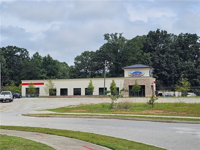 a view of a town with barn and large trees