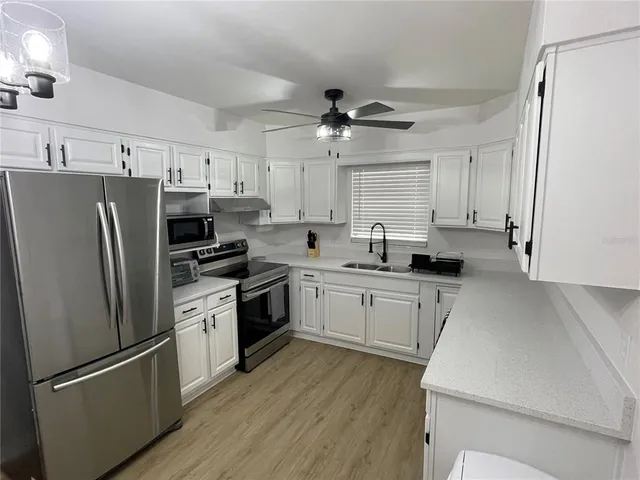 a view of a dining room with furniture and a chandelier fan