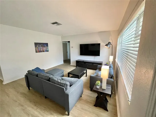 a large kitchen with stainless steel appliances a stove refrigerator and chandelier