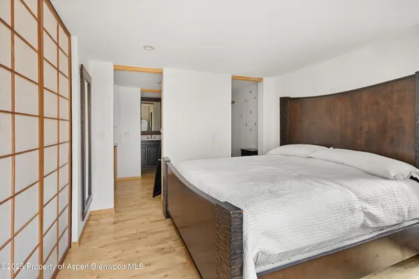 a bedroom with a bed and a painting on the wall