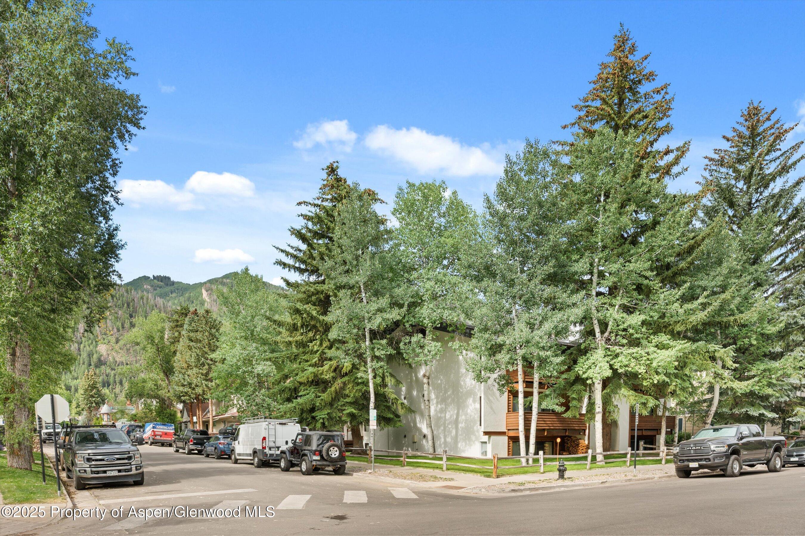 935 East Hopkins Avenue, Unit 7 Aspen, CO 81611 - Photo 5 of 17 a city street with lots of trees and cars parked on the side of road