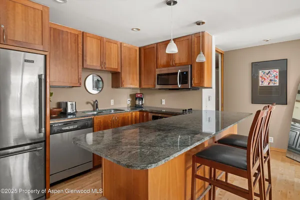 a kitchen with stainless steel appliances granite countertop a sink microwave and stove