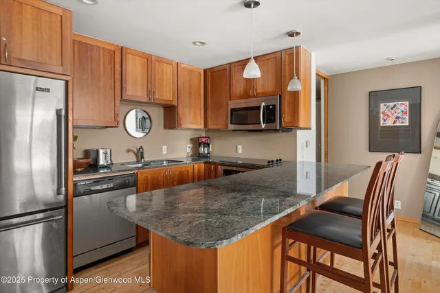 a kitchen with stainless steel appliances granite countertop a sink microwave and stove