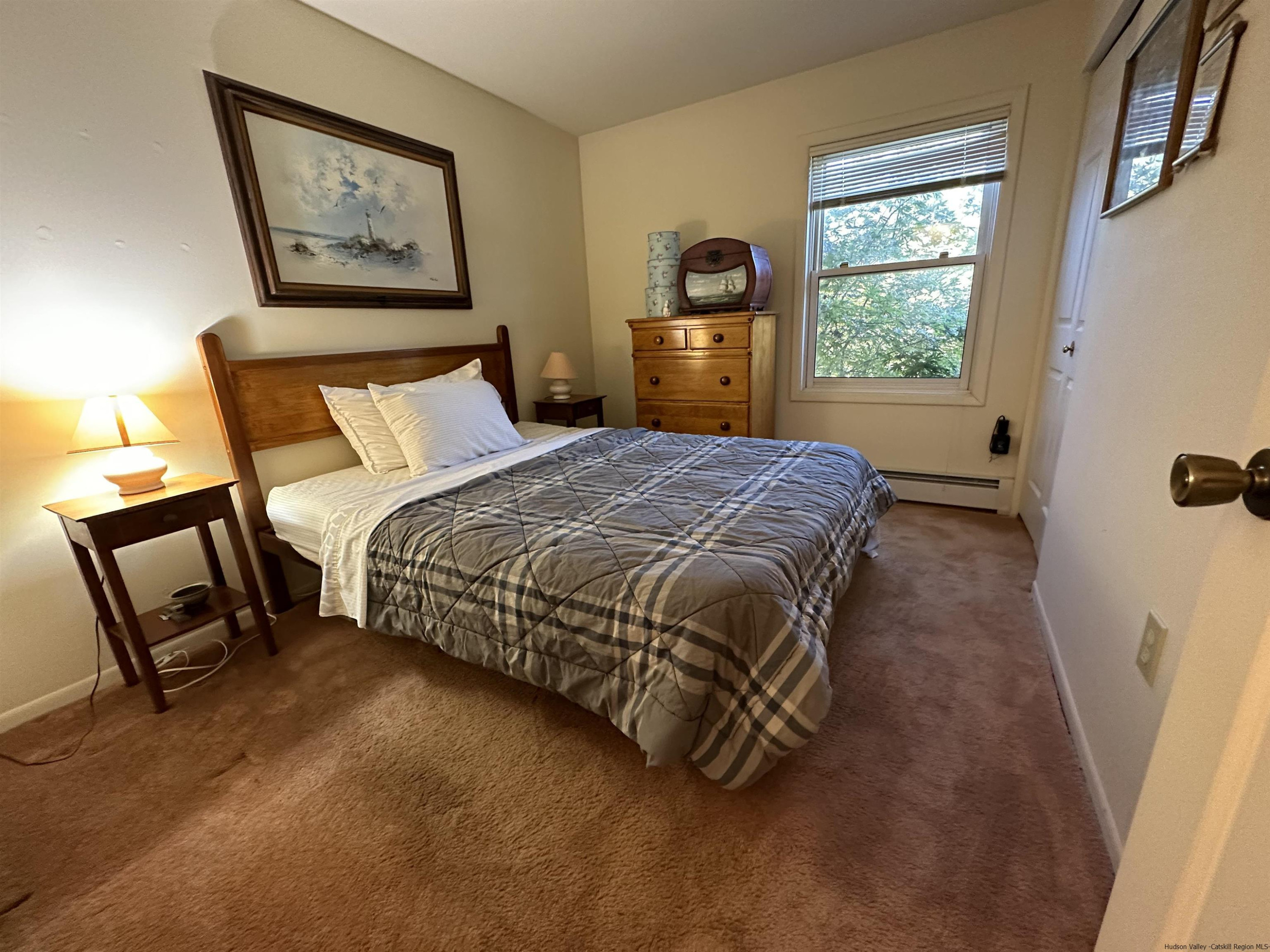 343 Cascade Drive Kingston, NY 12401 - Photo 12 of 33 a bedroom with a bed painting on the wall and a window