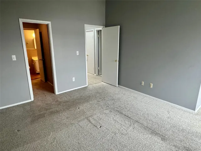an empty room with closet and mirror